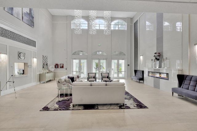 tiled living room featuring a glass covered fireplace and a notable chandelier