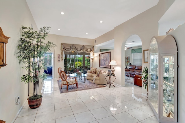 living room featuring arched walkways, light tile patterned floors, recessed lighting, a ceiling fan, and baseboards