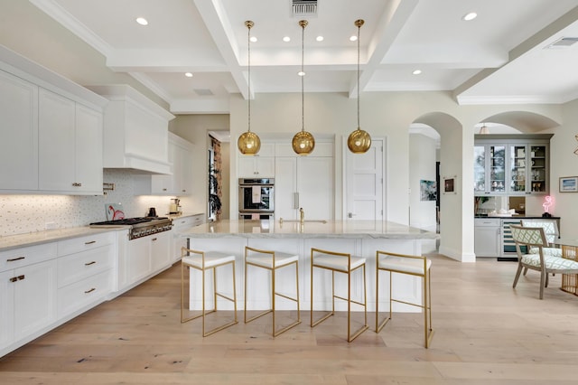 kitchen featuring wine cooler, stainless steel gas cooktop, tasteful backsplash, visible vents, and light wood-style flooring