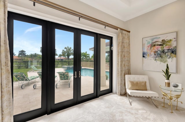 doorway featuring a wealth of natural light, french doors, crown molding, and carpet