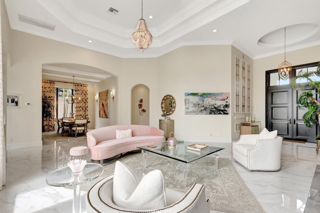 living room featuring marble finish floor, a tray ceiling, and a notable chandelier