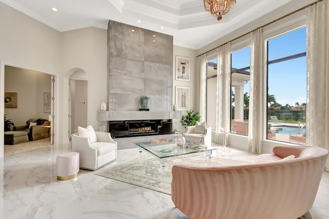 living room with marble finish floor, a high ceiling, arched walkways, and crown molding