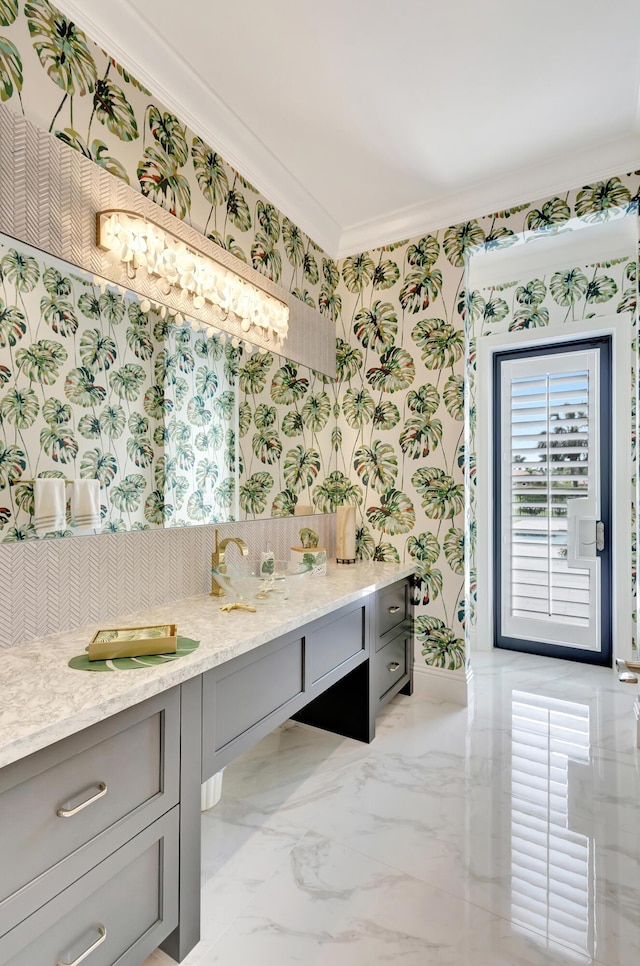 bathroom with wallpapered walls, baseboards, marble finish floor, crown molding, and vanity