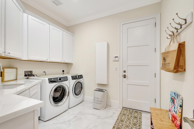 laundry room with marble finish floor, crown molding, cabinet space, washing machine and dryer, and baseboards