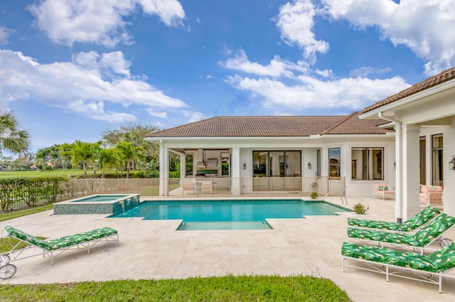 view of swimming pool featuring a pool with connected hot tub, a patio area, and fence