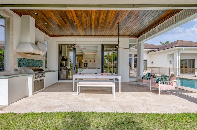 view of patio featuring exterior kitchen and a grill