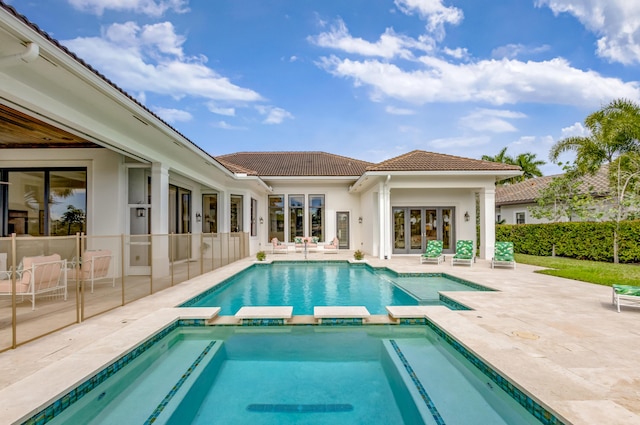 view of pool featuring french doors, a patio area, and a pool with connected hot tub