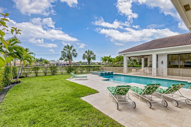 view of pool featuring a patio, a lawn, a fenced backyard, and a pool with connected hot tub