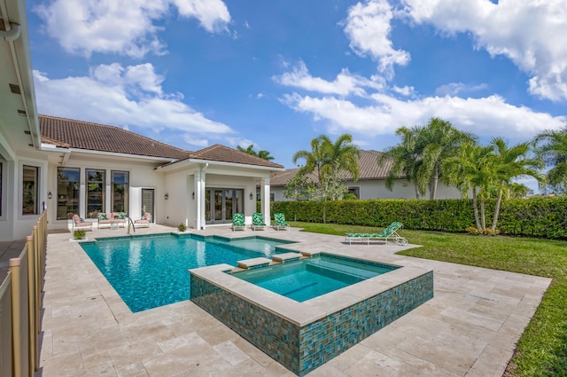 view of swimming pool featuring a patio, a yard, and a pool with connected hot tub