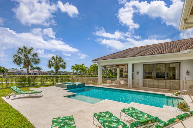 view of pool with a pool with connected hot tub, a patio area, and fence