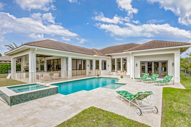 view of swimming pool with a pool with connected hot tub, a patio area, fence, and french doors