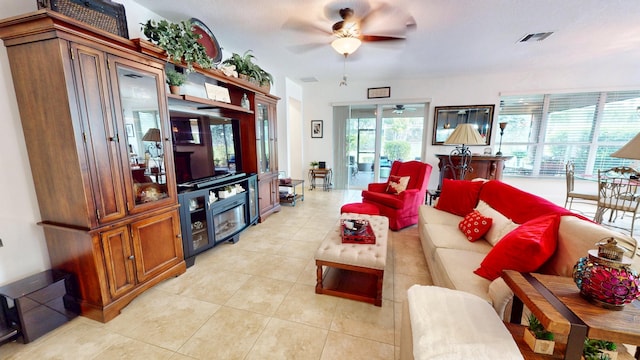 living area with light tile patterned floors, ceiling fan, and visible vents