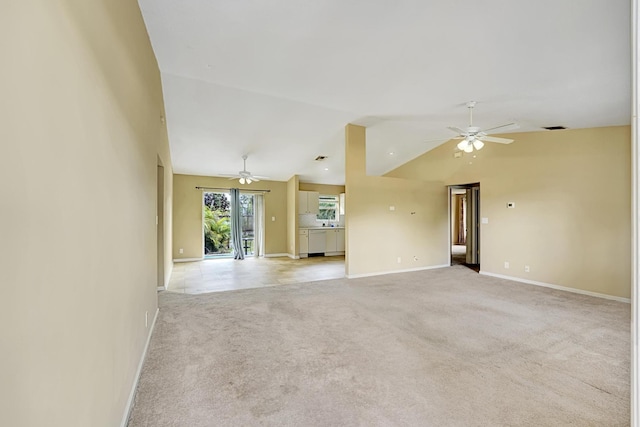 empty room with light carpet, visible vents, a ceiling fan, vaulted ceiling, and baseboards