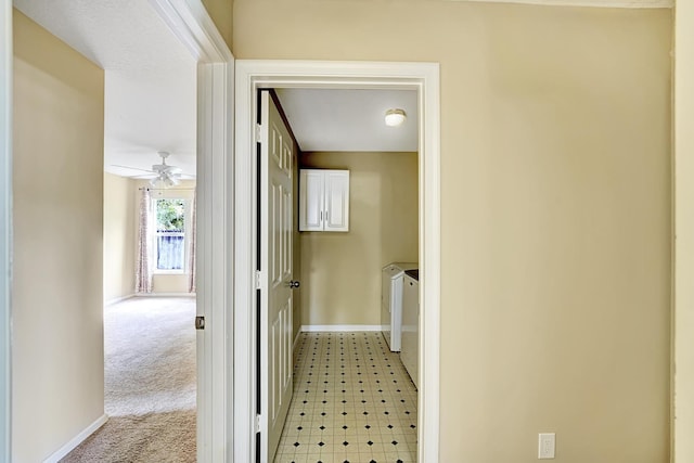 corridor featuring light colored carpet and baseboards