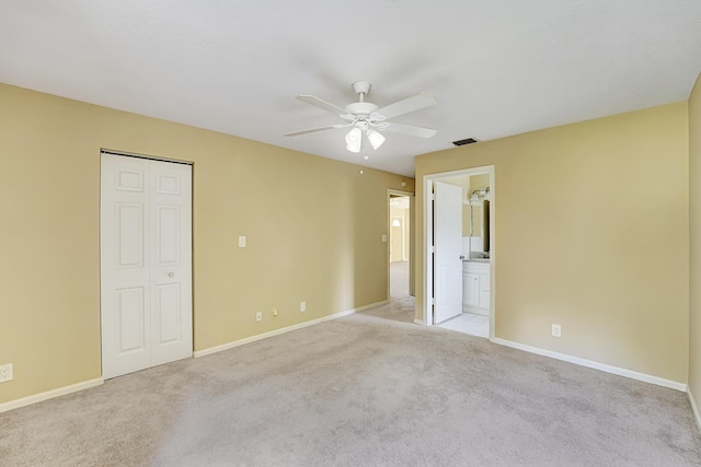 unfurnished bedroom featuring visible vents, ensuite bath, light carpet, and baseboards