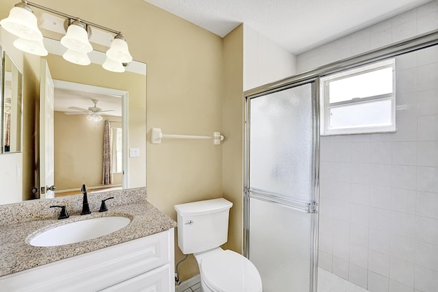 bathroom featuring toilet, a stall shower, a ceiling fan, and vanity