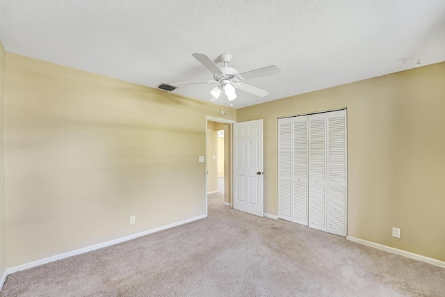 unfurnished bedroom featuring light colored carpet, a closet, visible vents, and a textured ceiling