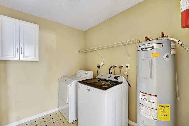 laundry room featuring separate washer and dryer, baseboards, water heater, cabinet space, and light floors