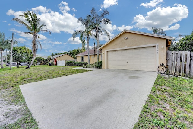 single story home with concrete driveway, a front yard, fence, and stucco siding