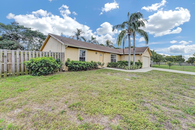 single story home featuring a garage, concrete driveway, stucco siding, fence, and a front yard