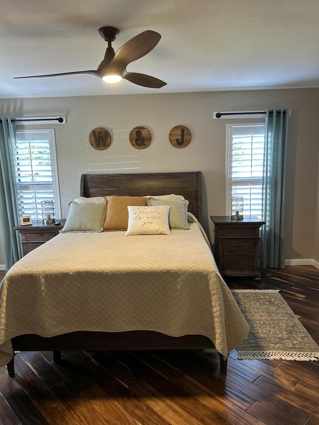 bedroom featuring wood finished floors, baseboards, a ceiling fan, and multiple windows