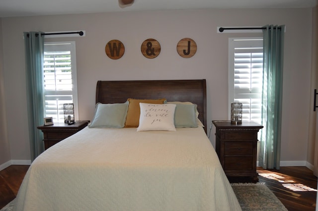 bedroom with baseboards and dark wood finished floors