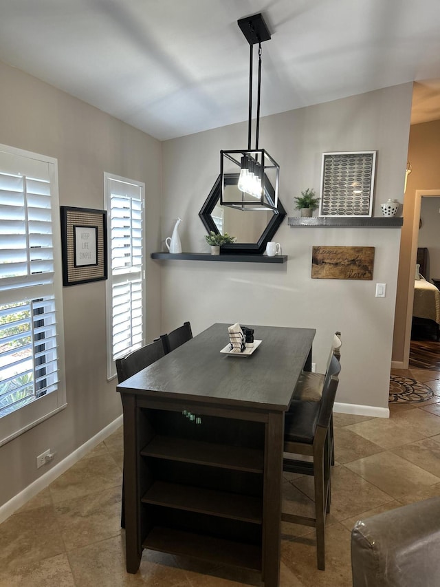dining area featuring baseboards and tile patterned floors