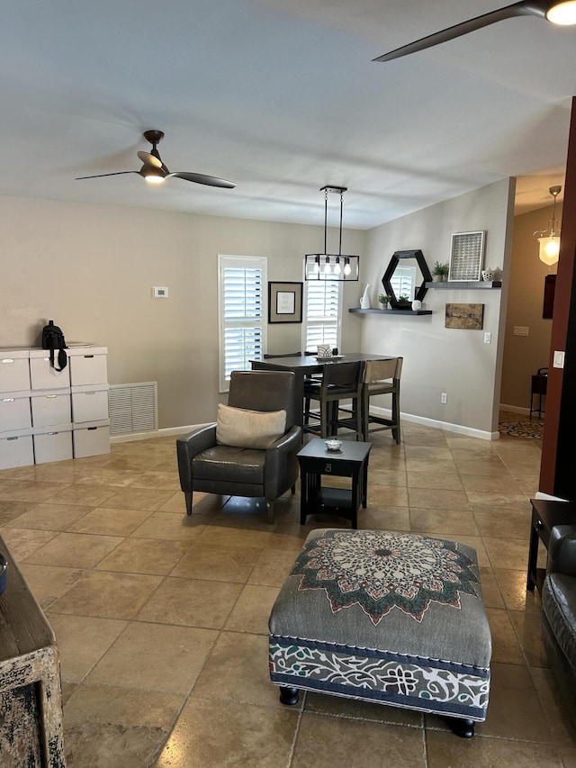 tiled living area with visible vents, baseboards, and a ceiling fan