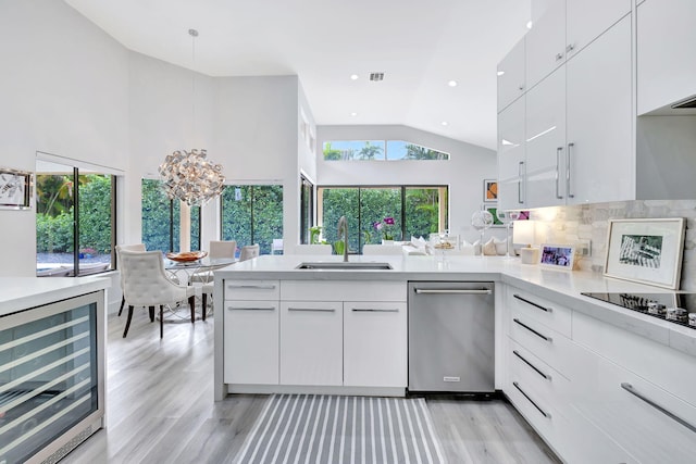 kitchen with white cabinets, dishwasher, wine cooler, light countertops, and a sink