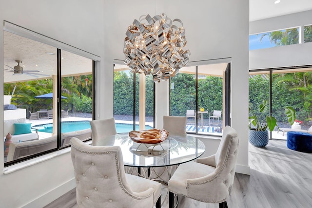 dining room with a notable chandelier, baseboards, and wood finished floors