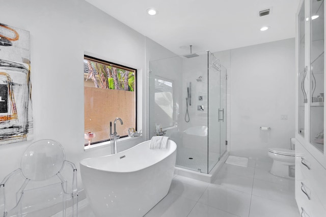 full bathroom featuring visible vents, a freestanding bath, toilet, a shower stall, and tile patterned floors