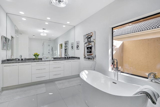 bathroom featuring double vanity, a stall shower, a soaking tub, a sink, and recessed lighting