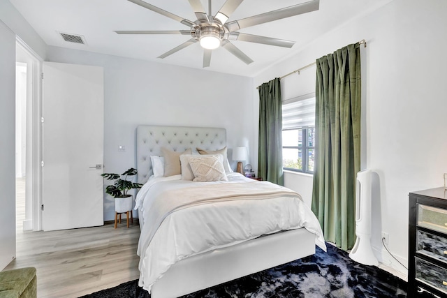 bedroom featuring light wood-style flooring, visible vents, and ceiling fan