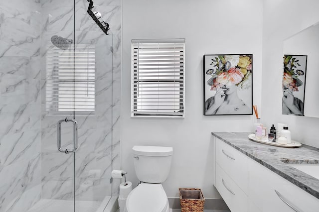 bathroom featuring toilet, vanity, and a marble finish shower