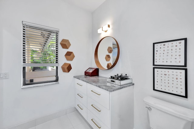 bathroom featuring vanity, tile patterned flooring, toilet, and baseboards