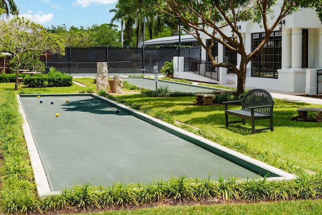 view of community with a yard and fence