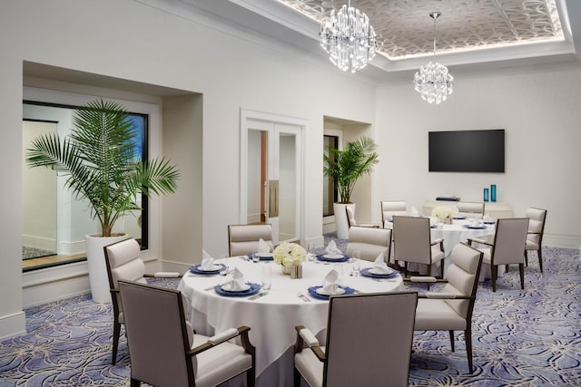 dining room with baseboards, a tray ceiling, and a notable chandelier