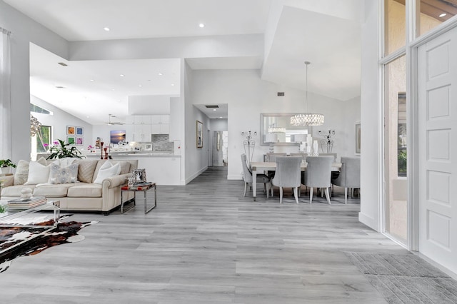 living area featuring light wood-style floors, high vaulted ceiling, a wealth of natural light, and recessed lighting