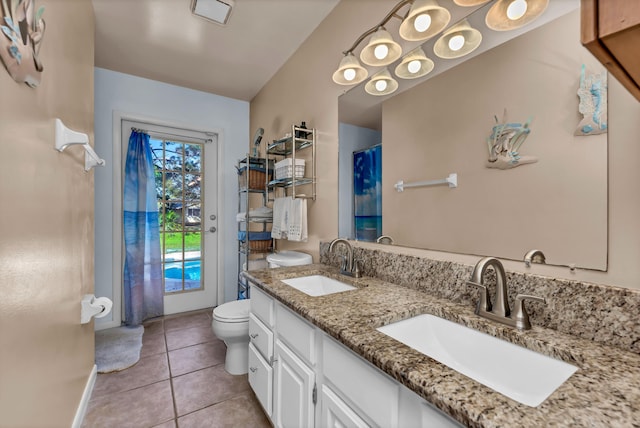 bathroom featuring double vanity, a sink, toilet, and tile patterned floors