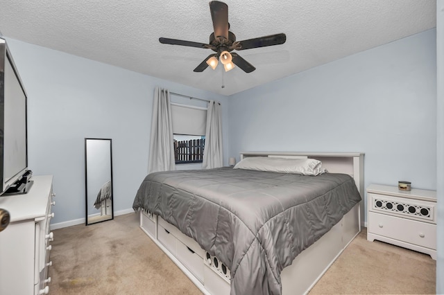 bedroom featuring light carpet, a textured ceiling, and baseboards