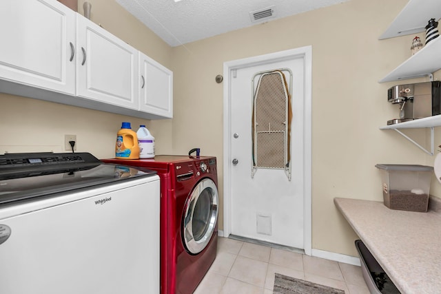 laundry area with cabinet space, visible vents, washer and clothes dryer, a textured ceiling, and light tile patterned flooring