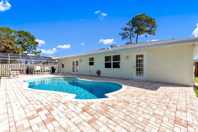 view of swimming pool featuring a fenced in pool, french doors, glass enclosure, and a patio