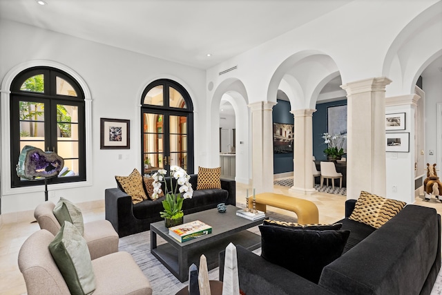 tiled living room with ornate columns, arched walkways, and recessed lighting