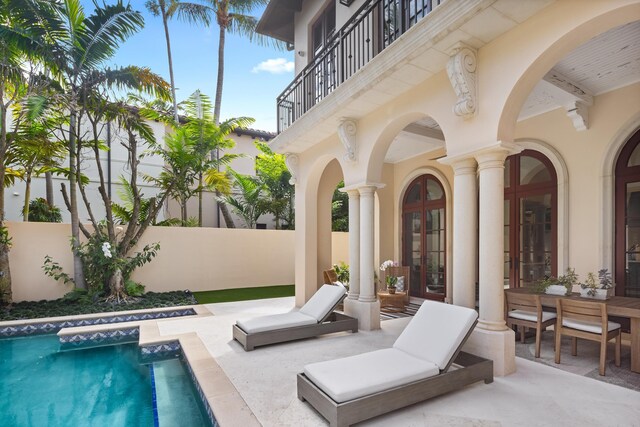 exterior space featuring a patio area, fence, a fenced in pool, and french doors