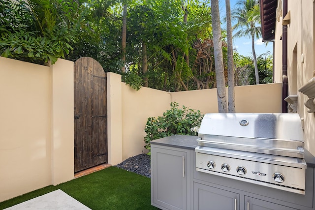 view of patio / terrace with a grill, a gate, and fence