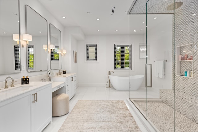 bathroom featuring a freestanding bath, tile patterned floors, a sink, and a shower stall