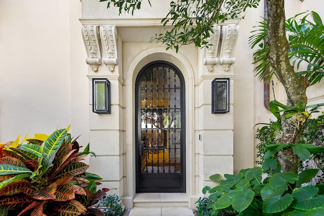 doorway to property featuring stucco siding