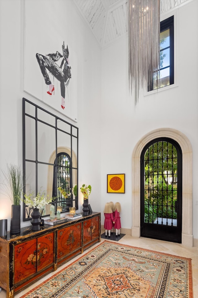 tiled foyer entrance featuring a healthy amount of sunlight and a high ceiling