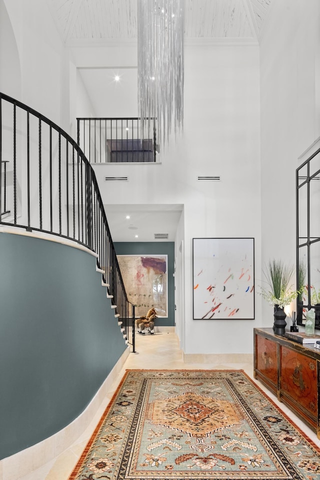 foyer with stairs, a high ceiling, and visible vents