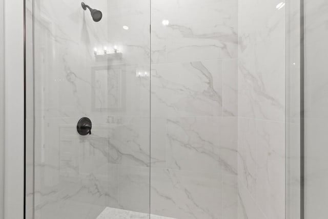 bathroom featuring a marble finish shower